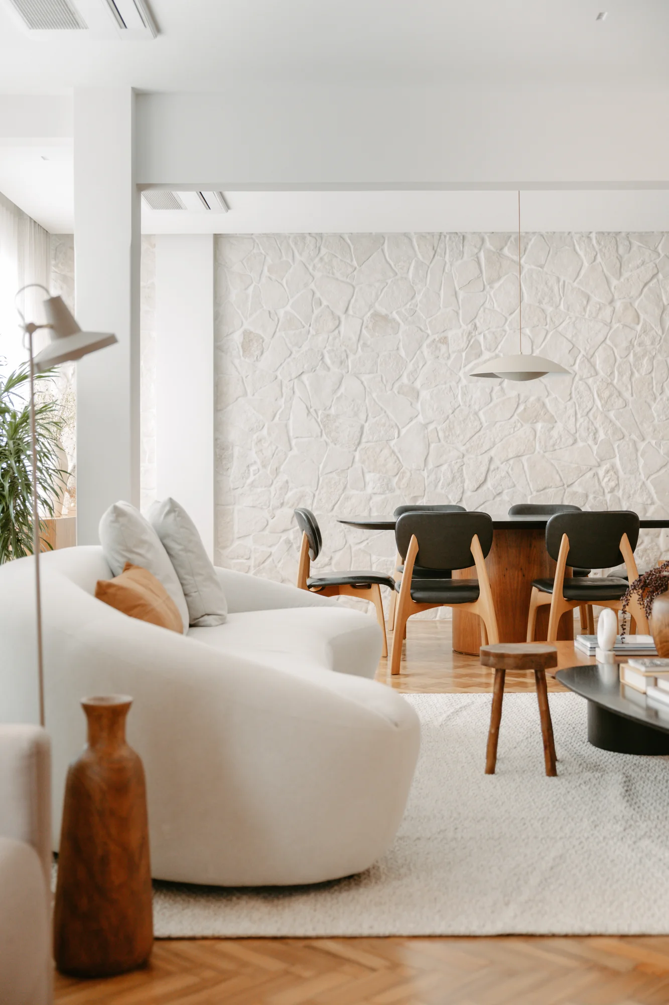 Sala de jantar vista do living, com parede texturizada e cadeiras escuras