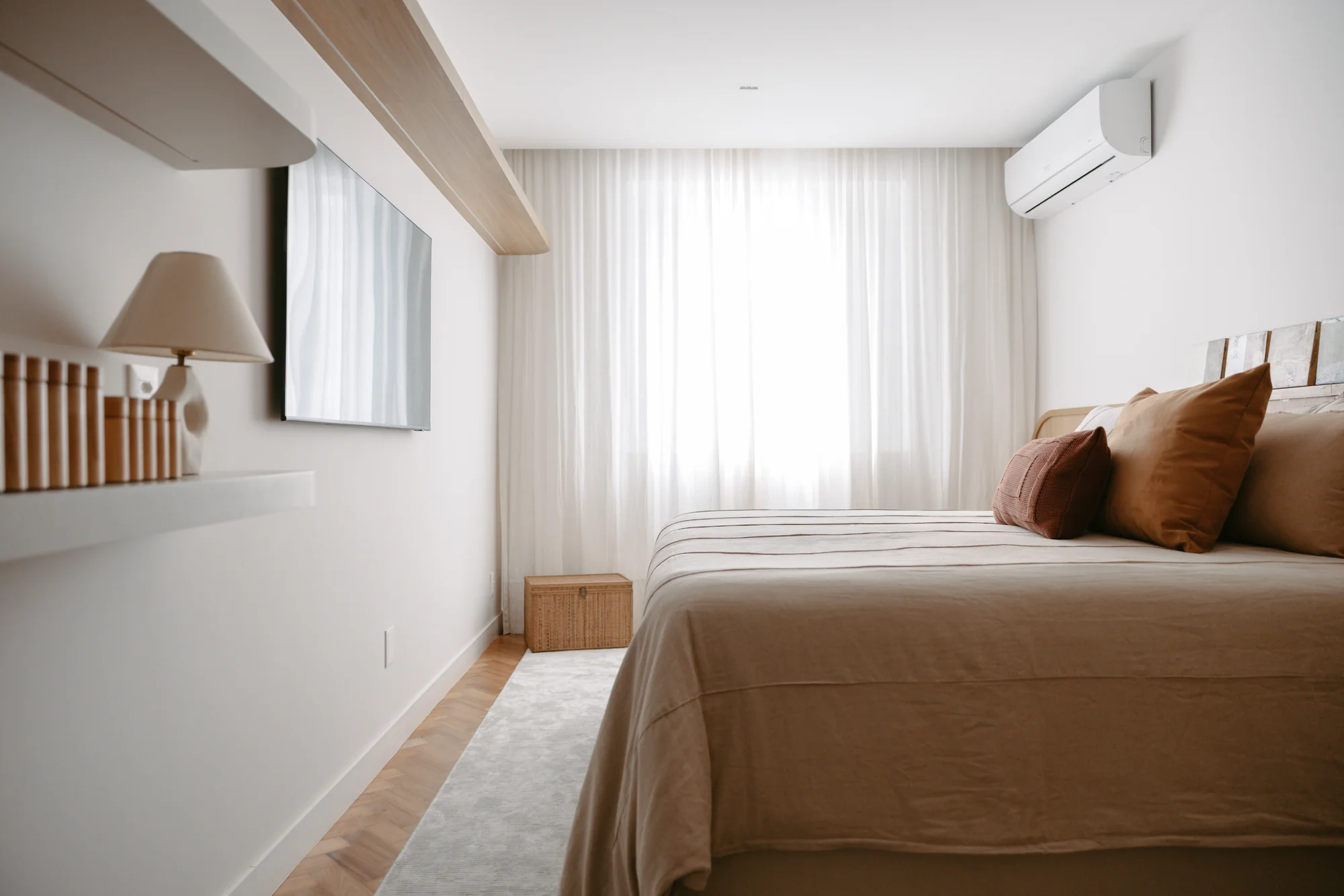 Quarto de casal com roupa de cama marrom e cortina de voil