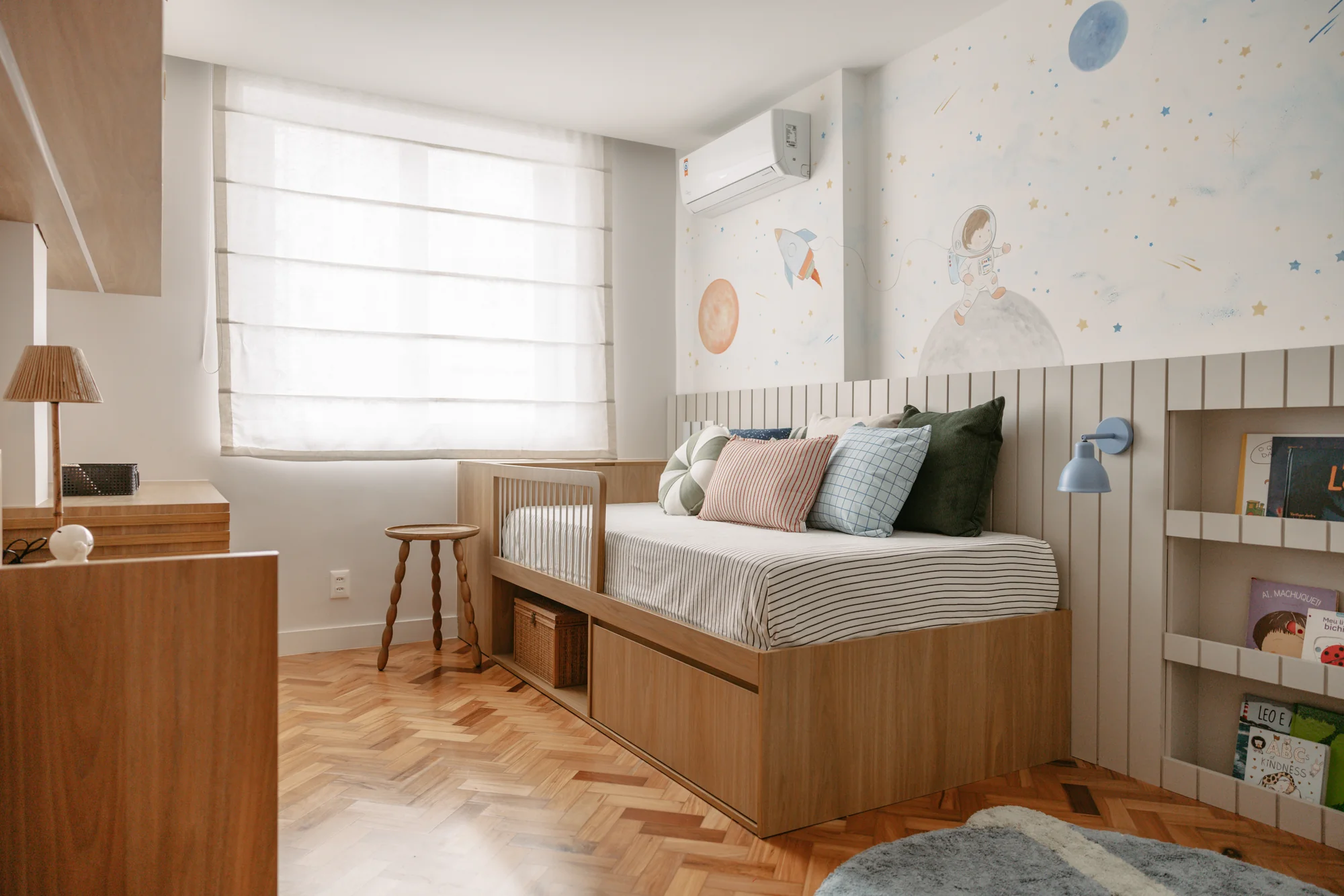 Quarto infantil com cama-baú, nichos de livros e papel de parede de estrelas