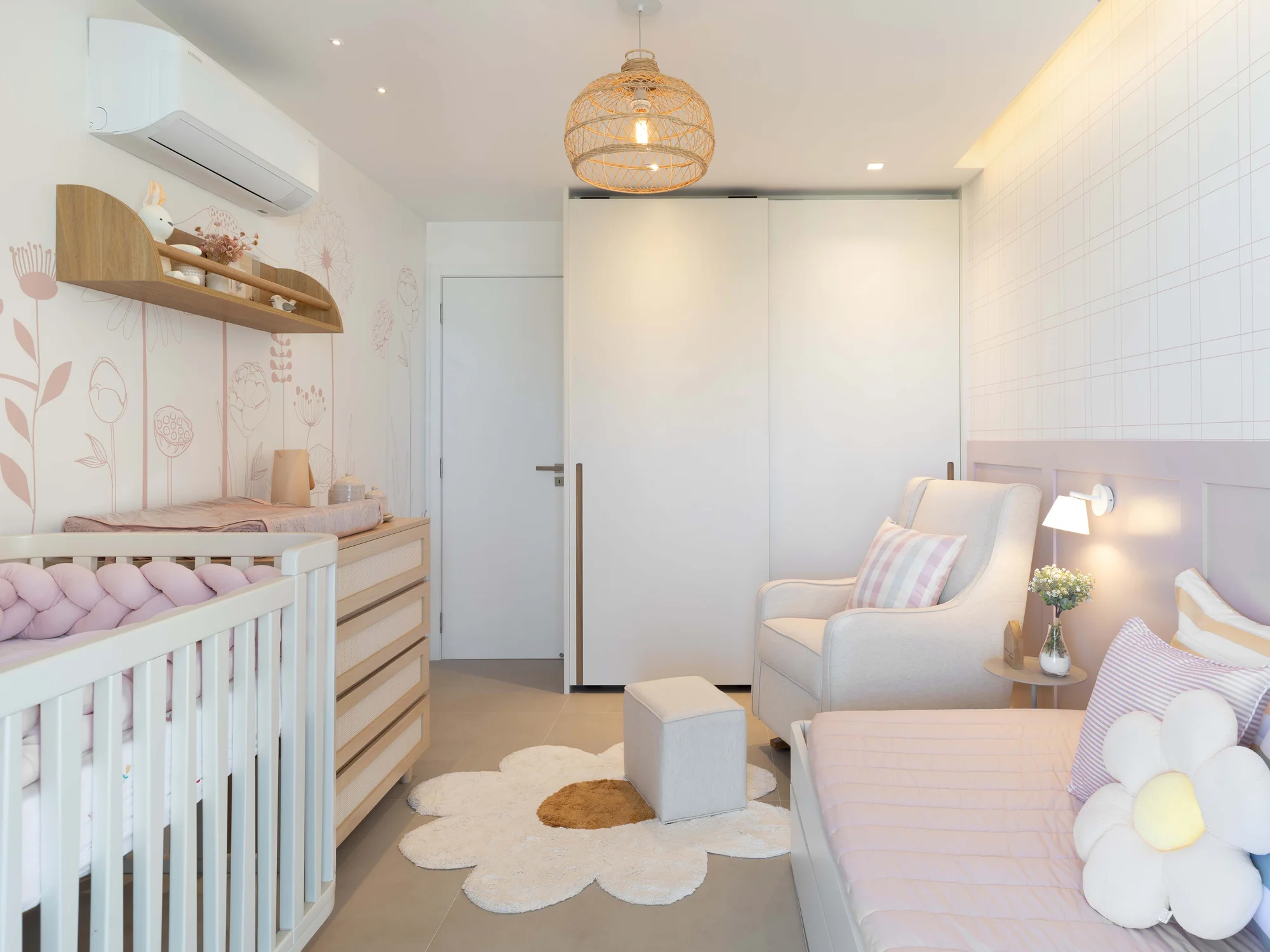 Quarto de bebê com berço, poltrona de amamentação e tapete em forma de flor
