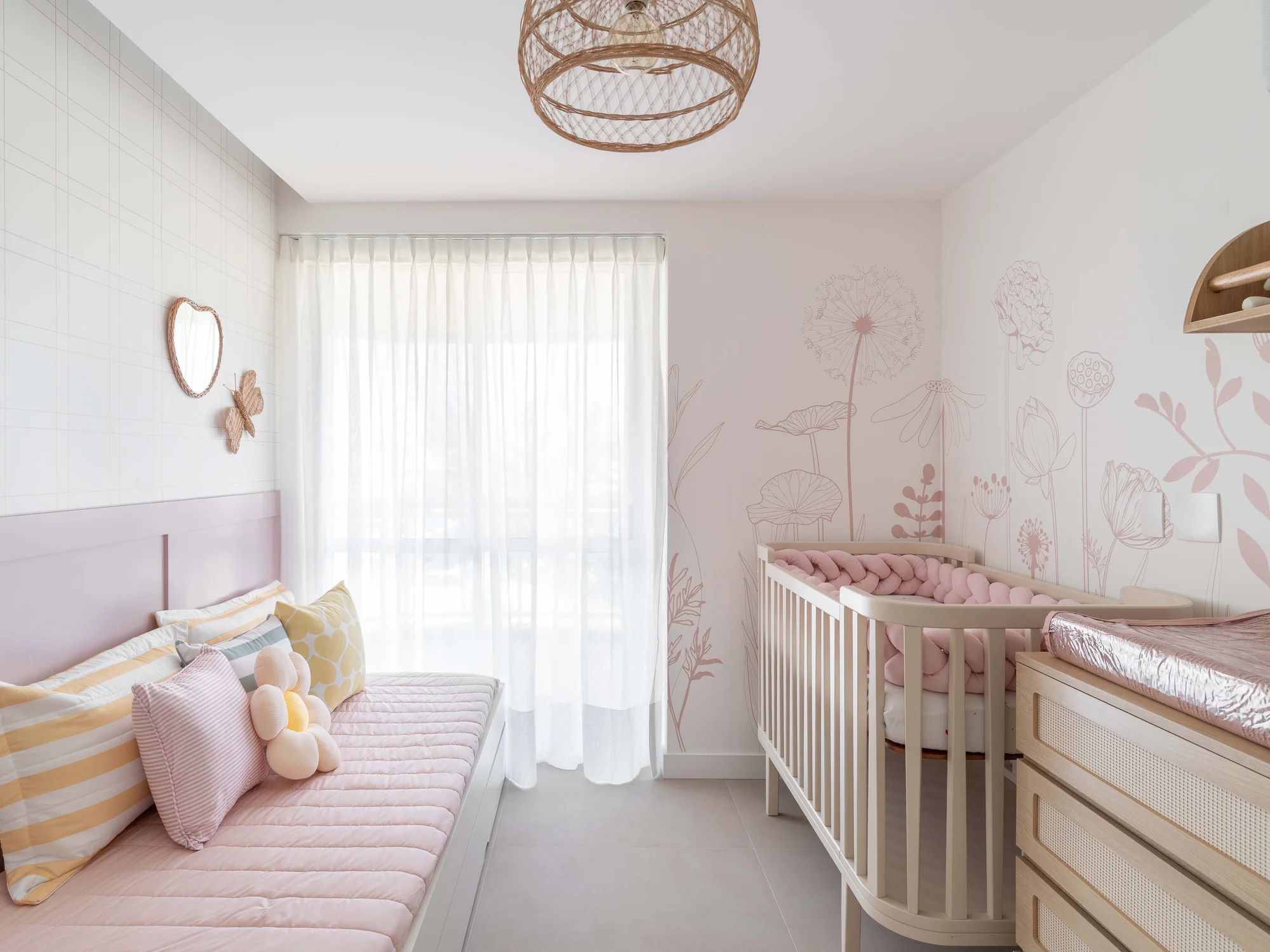 Quarto infantil com cama-sofá listrada, berço e cortina de voil