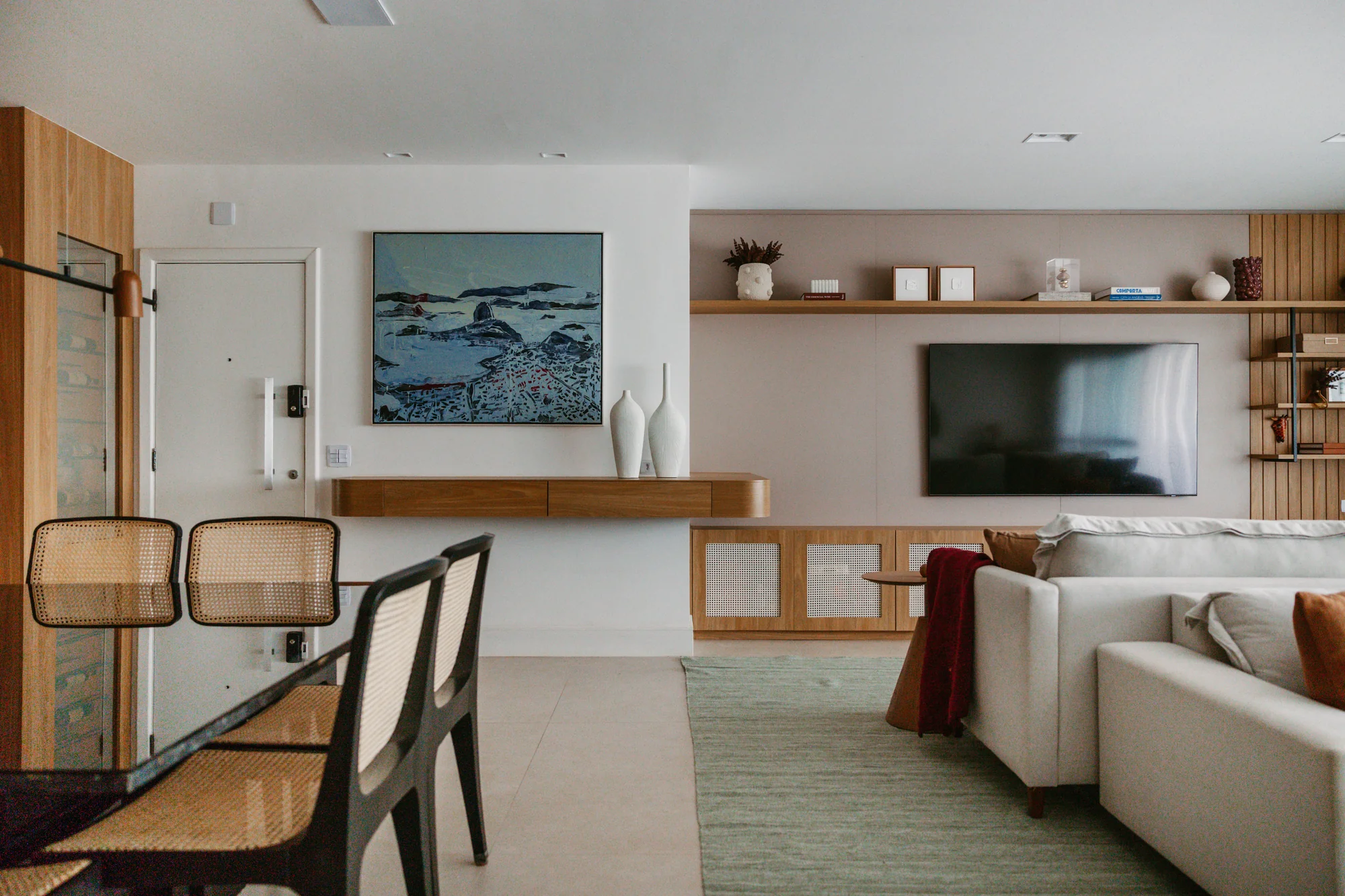 Living visto da sala de jantar, com painel de madeira e televisão