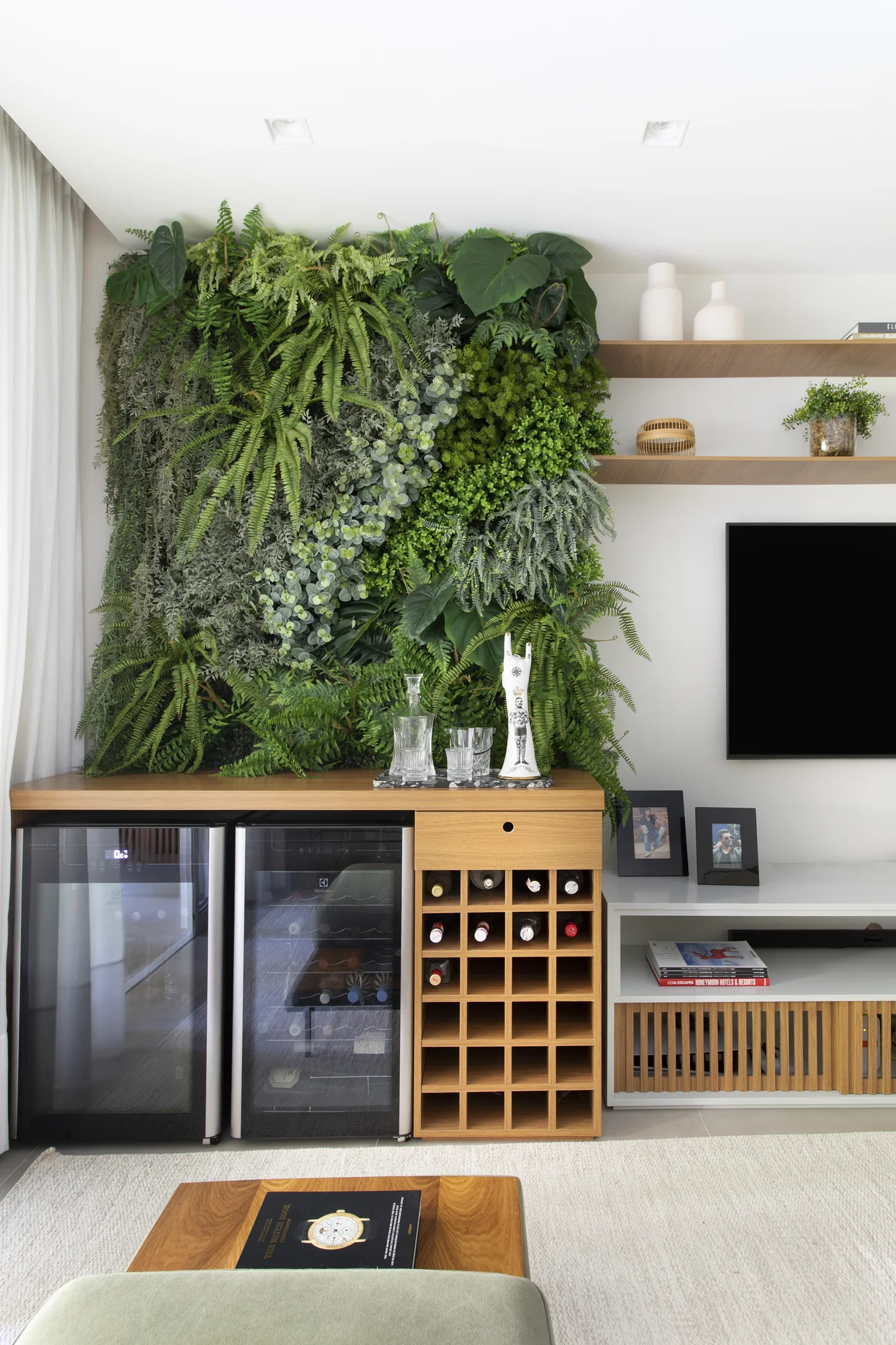 Jardim vertical sobre o bar, com adega climatizada e nichos de garrafas